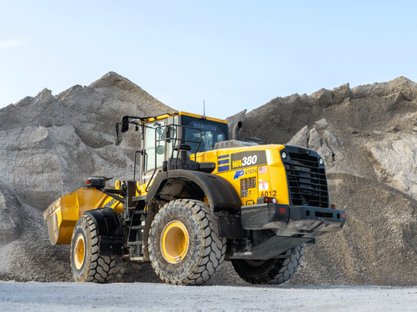 Front loader collecting material from a large mound.