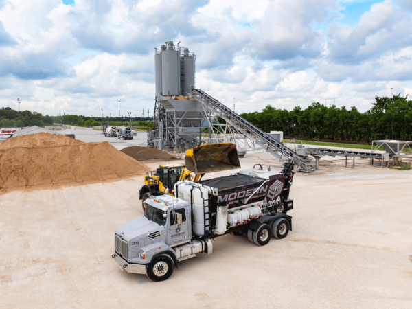 Volumetric mixer truck being loaded by front loader at the ready mix facility.